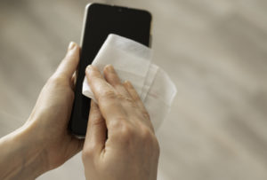 Woman disinfecting phone