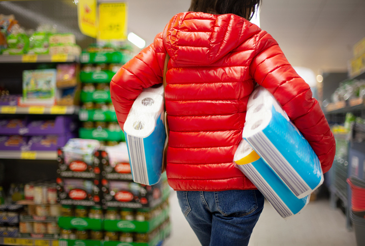 Customer shopping with toilet paper under their arms
